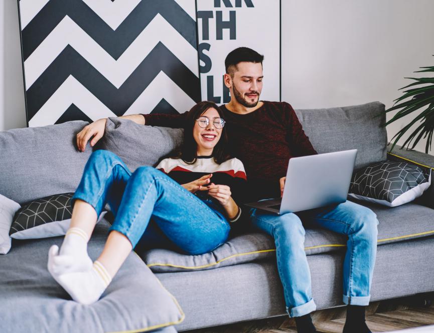 Lifestyle image of couple on sofa watching laptop